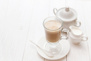 Raf coffee in transparent glass on a light wooden background. Delicious Russian most popular drinks. 