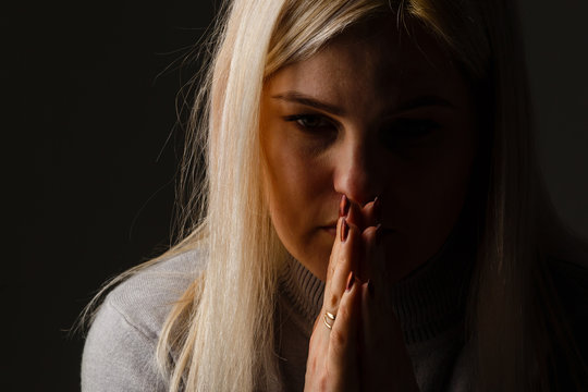 Religious girl praying on color background
