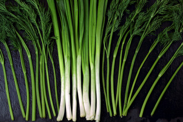 Raw vegetable leek and parsley on a black background