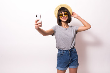 Young woman wear in straw hat and sunglasses making a video call or recording video blog on white background.