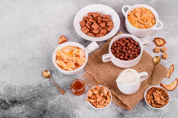 Obraz na płótnie Canvas Tasty and useful breakfast with flakes, milk, nuts and dried fruits. The healthy food loading with energy