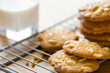 Peanut cookies on cooling rack with milk on wooden table