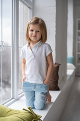 Fototapeta na wymiar Full length of beautiful little girl in dress standing and posing over white background