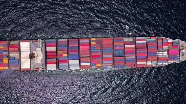 Cargo ship carries the container heading to the port where is many cranes at the edge. It is the important part of imported and exported economy. singapore