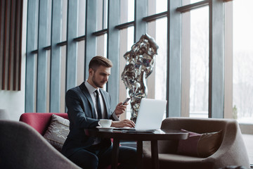 Young handsome businessman conducting negotiations with investors. Electronic business. Alternative...