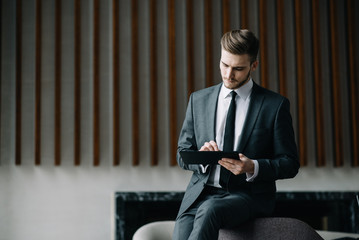 Young handsome businessman conducting negotiations with investors. Electronic business. Alternative...