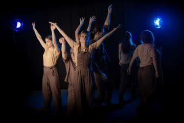 The actors on the stage play an emotion performance on a black background in stage light