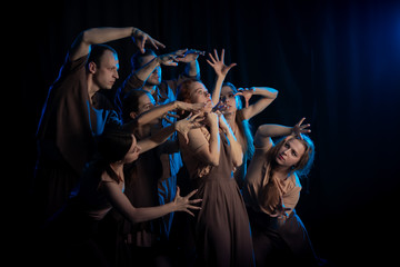 The actors on the stage play an emotion performance on a black background in stage light