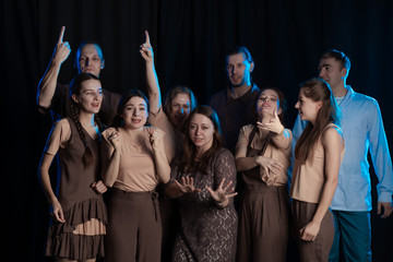 The actors on the stage play an emotion performance on a black background in stage light