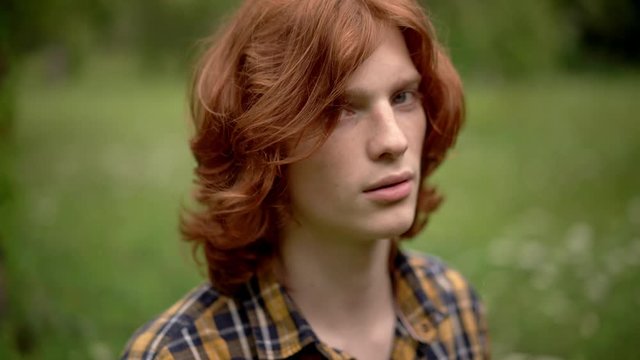 Charming guy with red hair smiles at camera.