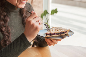 A stylish photo of a piece of a thin pie with fruit filling. Brown cake with berries.