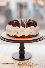 Stylish white cake standing on a cake stand on a high stalk