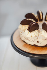 Stylish white cake standing on a cake stand on a high stalk