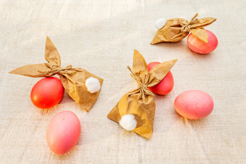 Easter bunny (rabbit) paper gift egg wrapping idea. Handicraft (homemade) concept for children (kids). On vintage cloth (linen) background
