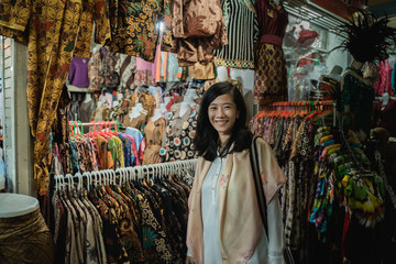 Fototapeta na wymiar portrait of asian woman shopping batik traditional indonesian pattern clothing in the market