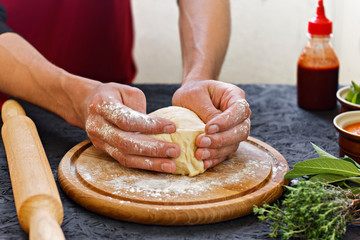 Dough. The process of making pizza. Ingredients for pizza. Kneading dough with your hands.