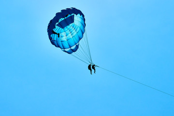 Parasailing flying against the background of the blue sky.  The concept of summer holidays, vacation.