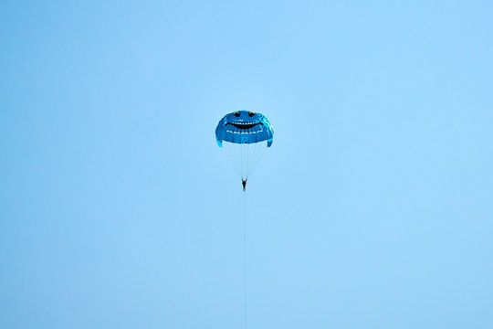 Parasailing flying against the background of the blue sky.  The concept of summer holidays, vacation.