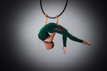 A female gymnast performing exercises on an air ring (hoop) © Oleksii