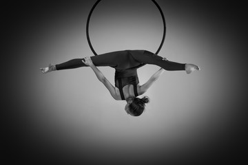 A female gymnast performing exercises on an air ring (hoop)
