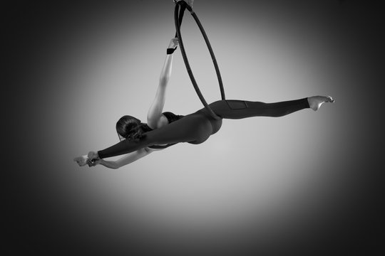 A female gymnast performing exercises on an air ring (hoop)