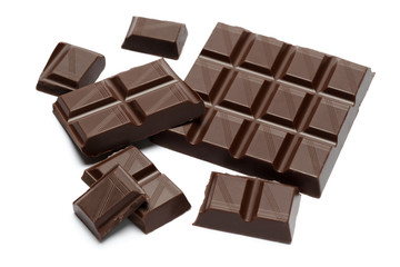 Dark organic chocolate pieces isolated on white background