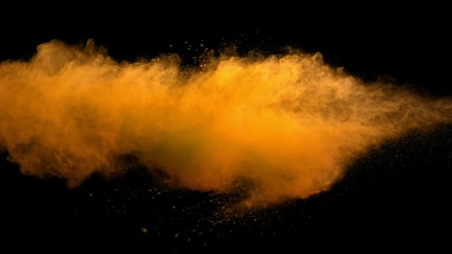 Super slowmotion shot of gold powder explosion isolated on black background.