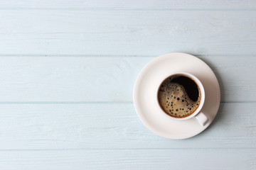 cup of coffee on wooden background top view.