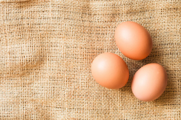 three brown eggs lie on sacking free space