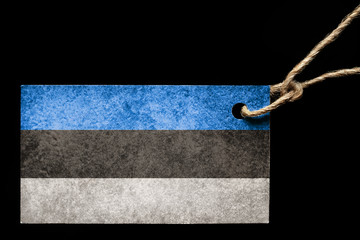 Cardboard label in color of the flag Estonia with a thread on a black background.