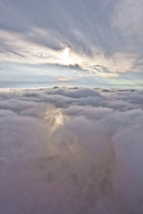 The sun shines through the clouds. Flying above the clouds (sea of clouds) foggy view from a great height Aerial view from a height in in Abkhazia