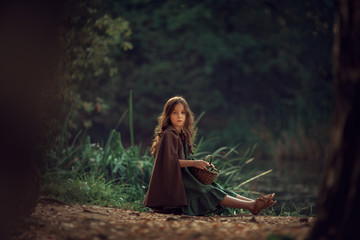 Girl in cape in the summer forest