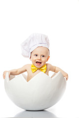 funny baby emotions. Little Chef. Adorable baby boy dressed in s chef's hat sitting in egg shell. isolated on white