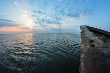 Fishing boat sailing at sunrise