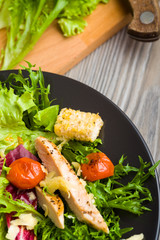 Healthy chicken salad with lettuce, grilled tomato, croutons, shredded cheese and grilled chicken