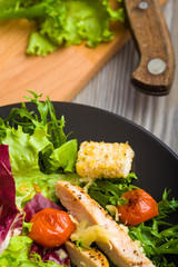 Healthy chicken salad with lettuce, grilled tomato, croutons, shredded cheese and grilled chicken