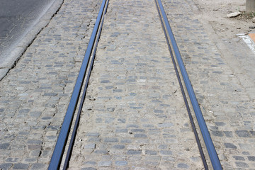 Tramway tracks straight empty perspective with cobblestone asphalt city street