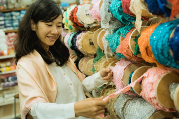 Fototapeta premium young asian woman shopping some fabric decoration and accessories