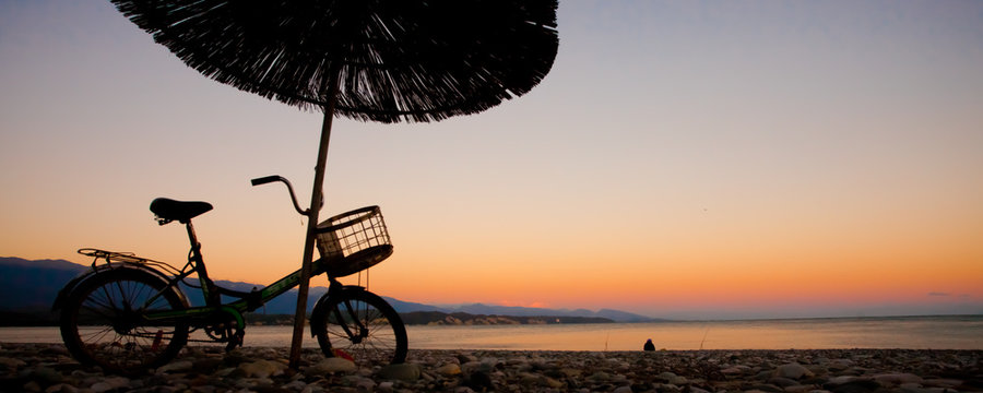 Beach umbrellas and a vintage bike by the sea. Tourismin Abkhazia.