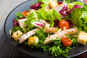 Healthy chicken salad with lettuce, grilled tomato, croutons, shredded cheese and grilled chicken