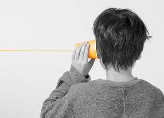 糸電話を持つ後ろ姿の少年