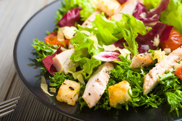 Healthy chicken salad with lettuce, grilled tomato, croutons, shredded cheese and grilled chicken