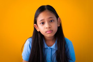 Portrait of serious asian cute girl isolated orange background. - 259133647