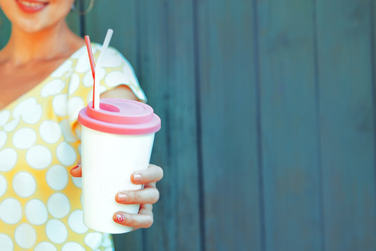  go green concept. Summer food. Eco life. A young girl is holding a cardboard cup with a fresh summer drink. Copy space. Eco products. Selective focus