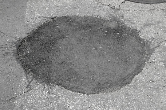 New and old asphalt surface circular patch city street pavement