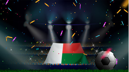 Fans hold the flag of Madagascar among silhouette of crowd audience in soccer stadium with confetti to celebrate football game. Concept design for football result template