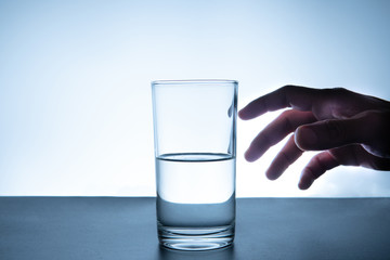 hand reaching out to catch a glass of freshwater
