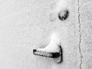 Door handle on the gate or gate is covered in snow in winter