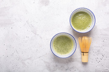 Top view of green tea matcha in a bowl on concrete surface. Horizontal orientation, top view