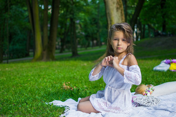 Beautiful little girl in a park on a picnic with straw basket and hat. Spring sunny concept. Happy mothers day.